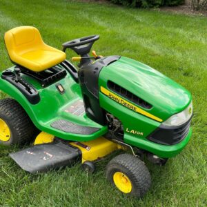 a green lawn mower sitting on top of a lush green field
